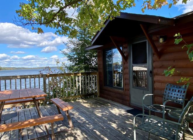 Deck area with picnic table, charcoal grill, and views of the lake.