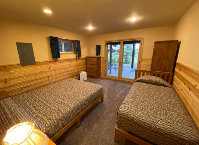 Downstairs bedroom with a queen, twin, and patio doors to the basement patio.