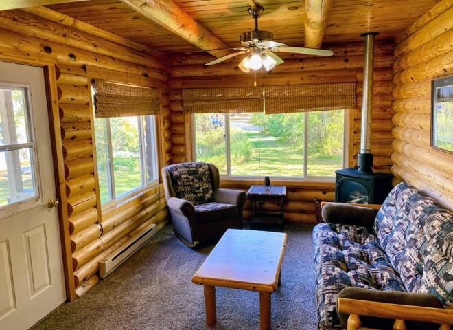 Living room with futon, recliner, gas fireplace, and views of your private yard next to the lake.
