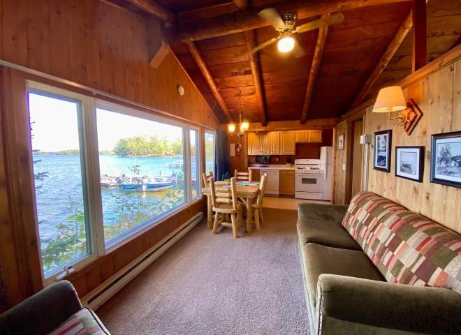 Living area with couch, chair, kitchen table, and front row views of Lake Vermilion.
