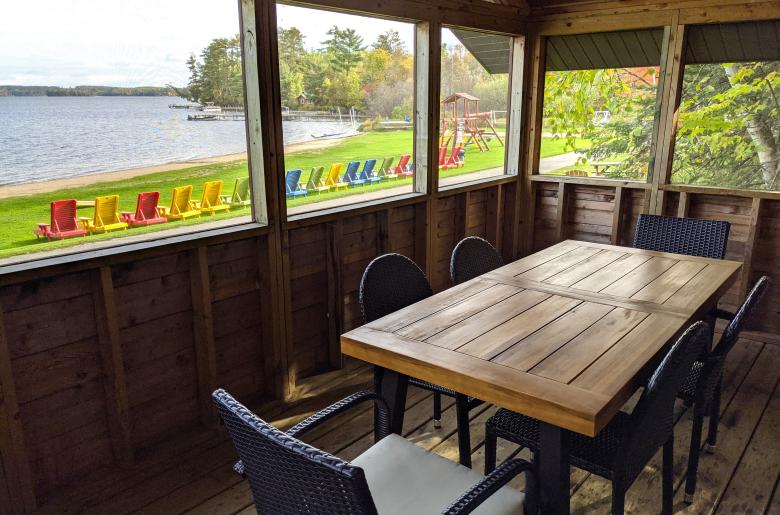 Screened porch area with seating and views of the beach.
