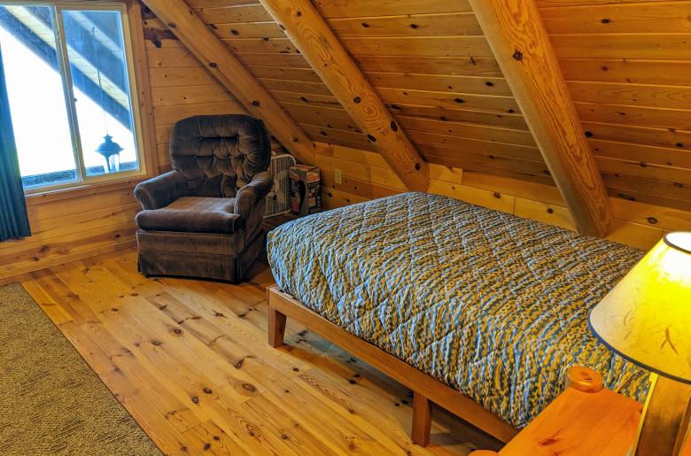 Loft bedroom with a twin and chair.