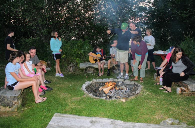 Families join together at a campfire for s'mores 