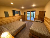 Downstairs bedroom with a queen, twin, and patio doors to the basement patio.