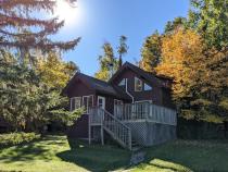 Exterior of two story Chickadee cabin, with the sun rising.