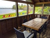 Screened porch area with seating and views of the beach.