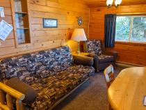 Living area with a futon, chair, and kitchen table.
