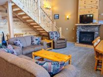 Living room with couch, loveseat, gas fireplace, and TV with streaming capabilities.
