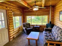 Living room with futon, recliner, gas fireplace, and views of your private yard next to the lake.