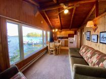 Living area with couch, chair, kitchen table, and front row views of Lake Vermilion.