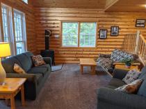 Living room with couch, loveseat, futon, and gas fireplace.