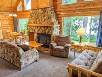 Living area with couch, recliner, futon, and wood burning fireplace.